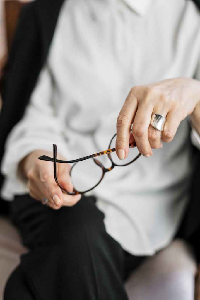 person holding brown framed eyeglasses